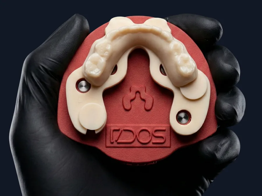 Modello stampato in 3D tenuto in mano, montato sulla piastra rossa DACOS Omni